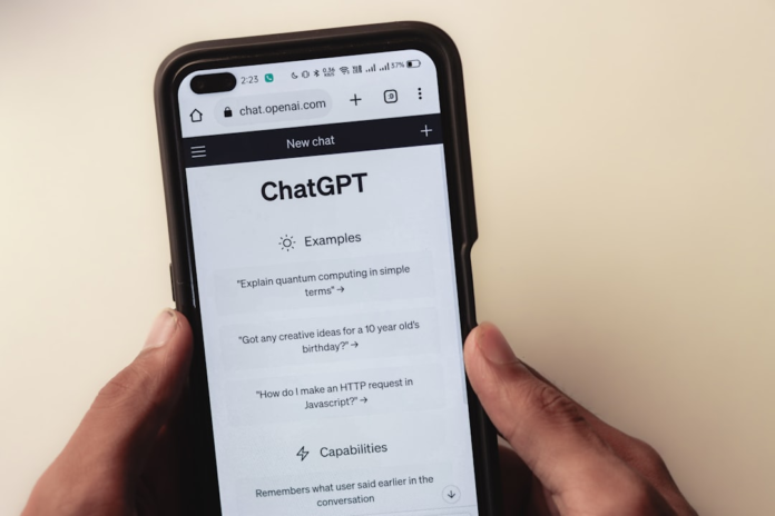 Hands hold a smartphone displaying the ChatGPT interface, symbolizing the advanced automation and personalized communication possible for new subscriber welcome emails.