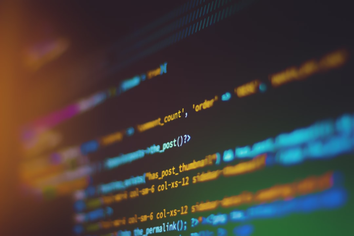 Close-up of vibrant, blurred computer code on a dark screen, illustrating the technical foundation and data processing central to Customer Data Platforms like Salesforce.