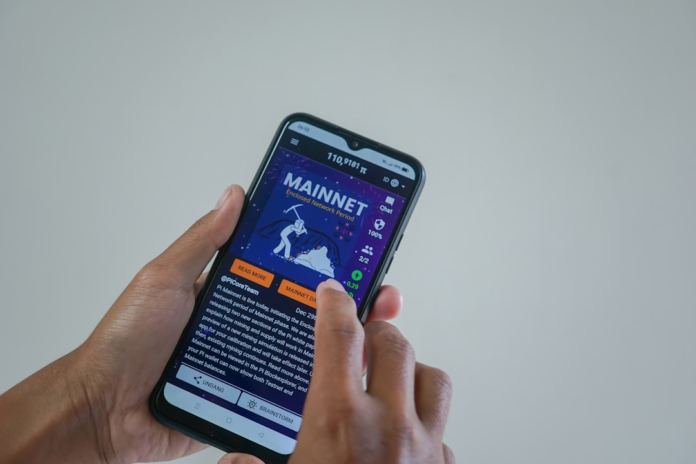 Hands hold a smartphone displaying a 'MAINNET' digital currency app interface, symbolizing digital engagement and potential for online monetization.