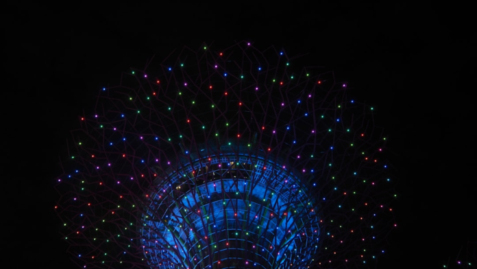 A futuristic Supertree structure, adorned with thousands of glowing multi-colored lights against a dark night sky, visually represents the intricate, interconnected networks of intelligent automation tools in modern marketing.