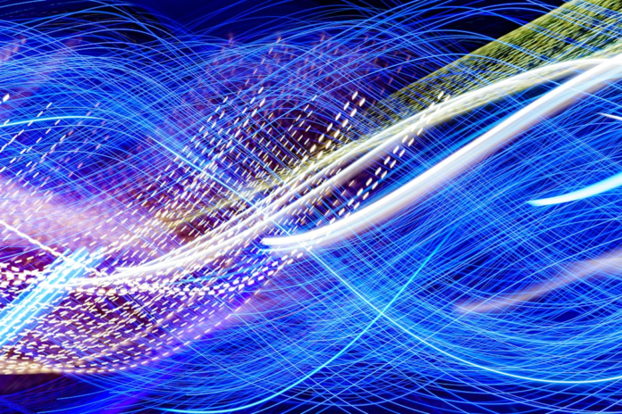 Flowing blue and white light patterns visually express the speed and connectivity of email marketing automation and system integrations.